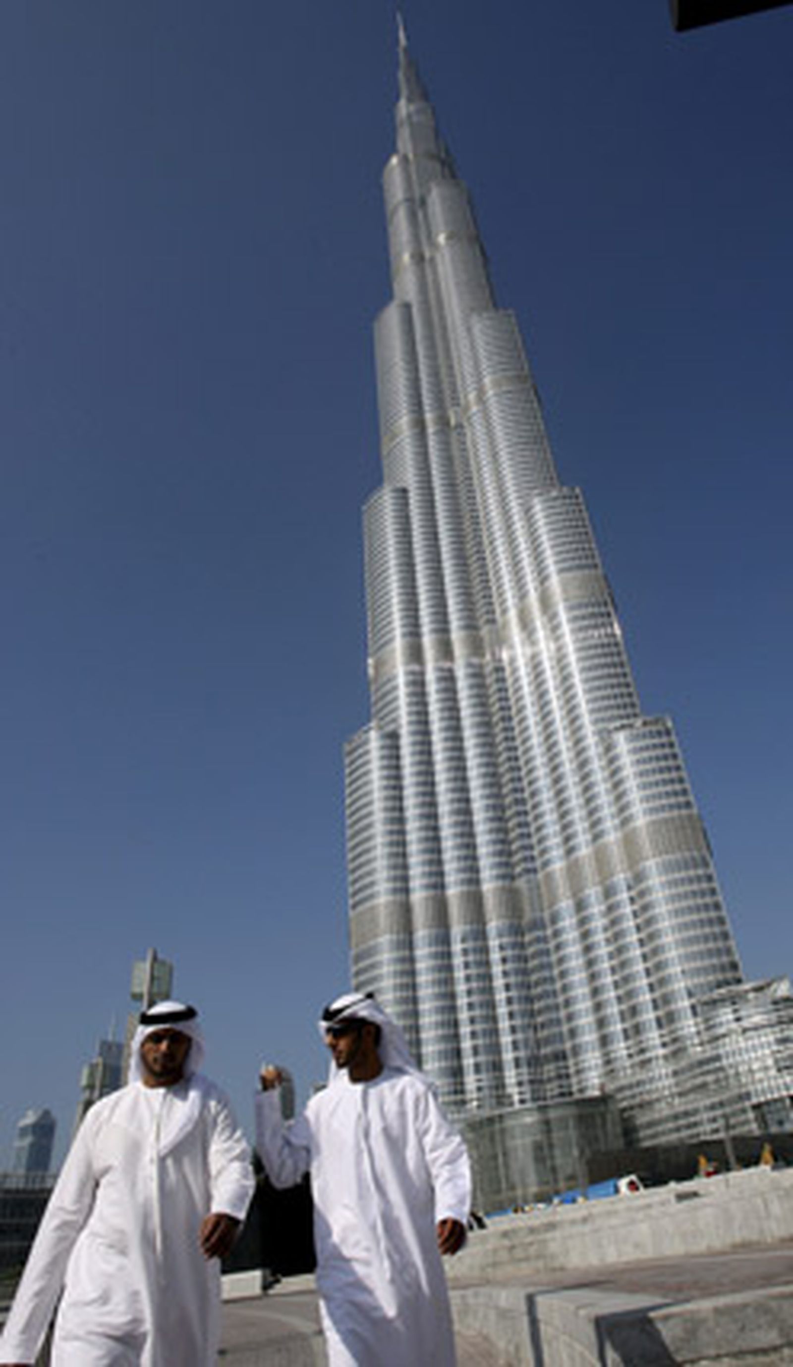 Un grupo de dubaitíes pasea bajo la Burj Dubai. / Efe