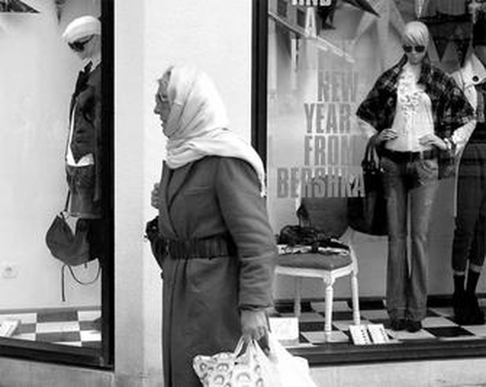 Una señora pasa por delante del escaparate de un establecimiento de Cádiz.