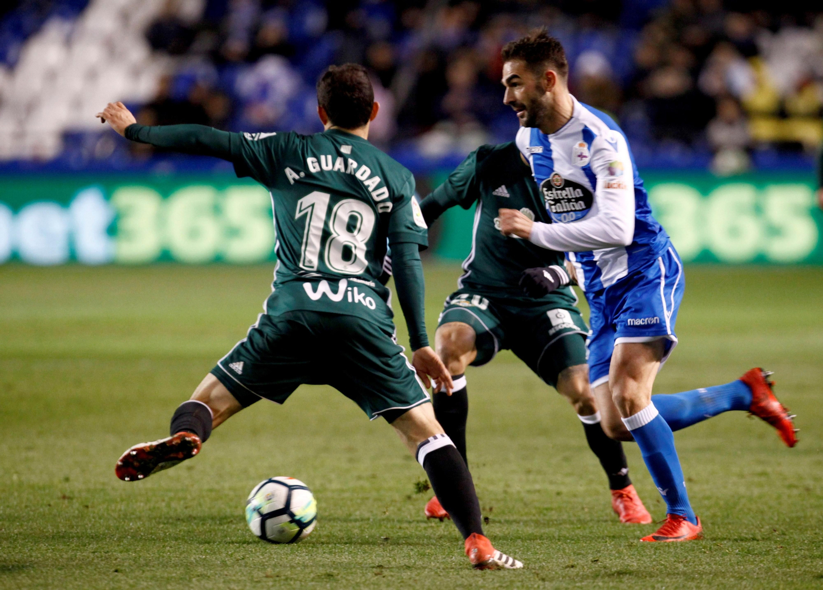 Guardado, de espaldas, trata de robar el balón