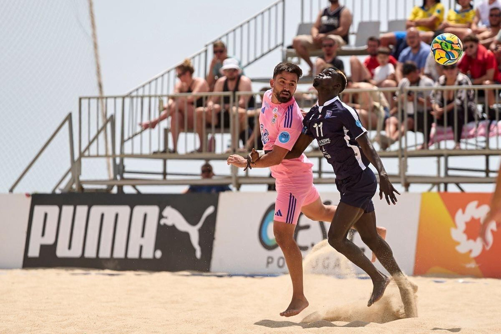Un jugador del Recre fútbol playa salta con un rival.