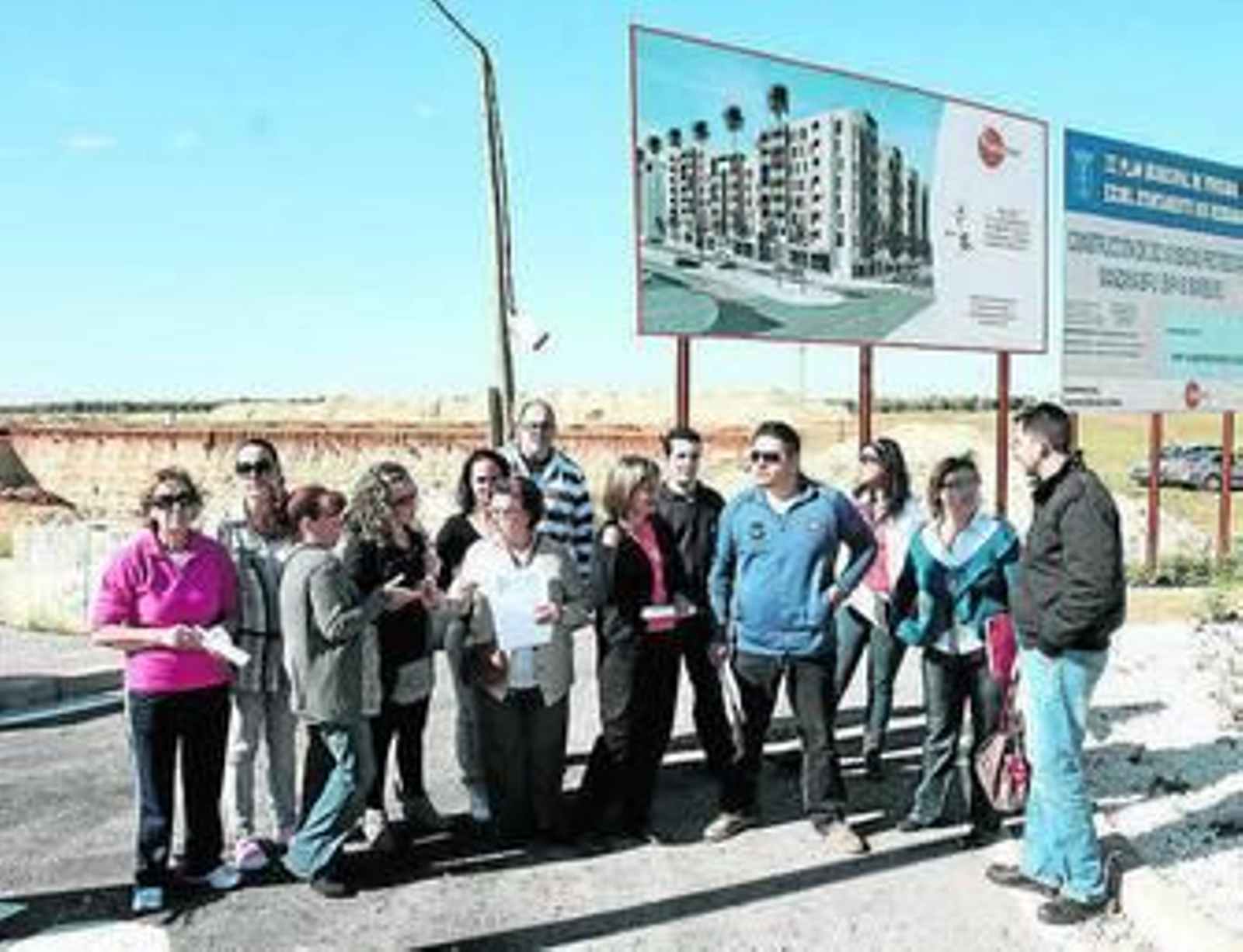 Algunos de los afectados ante el cartel que anuncia la promoción.