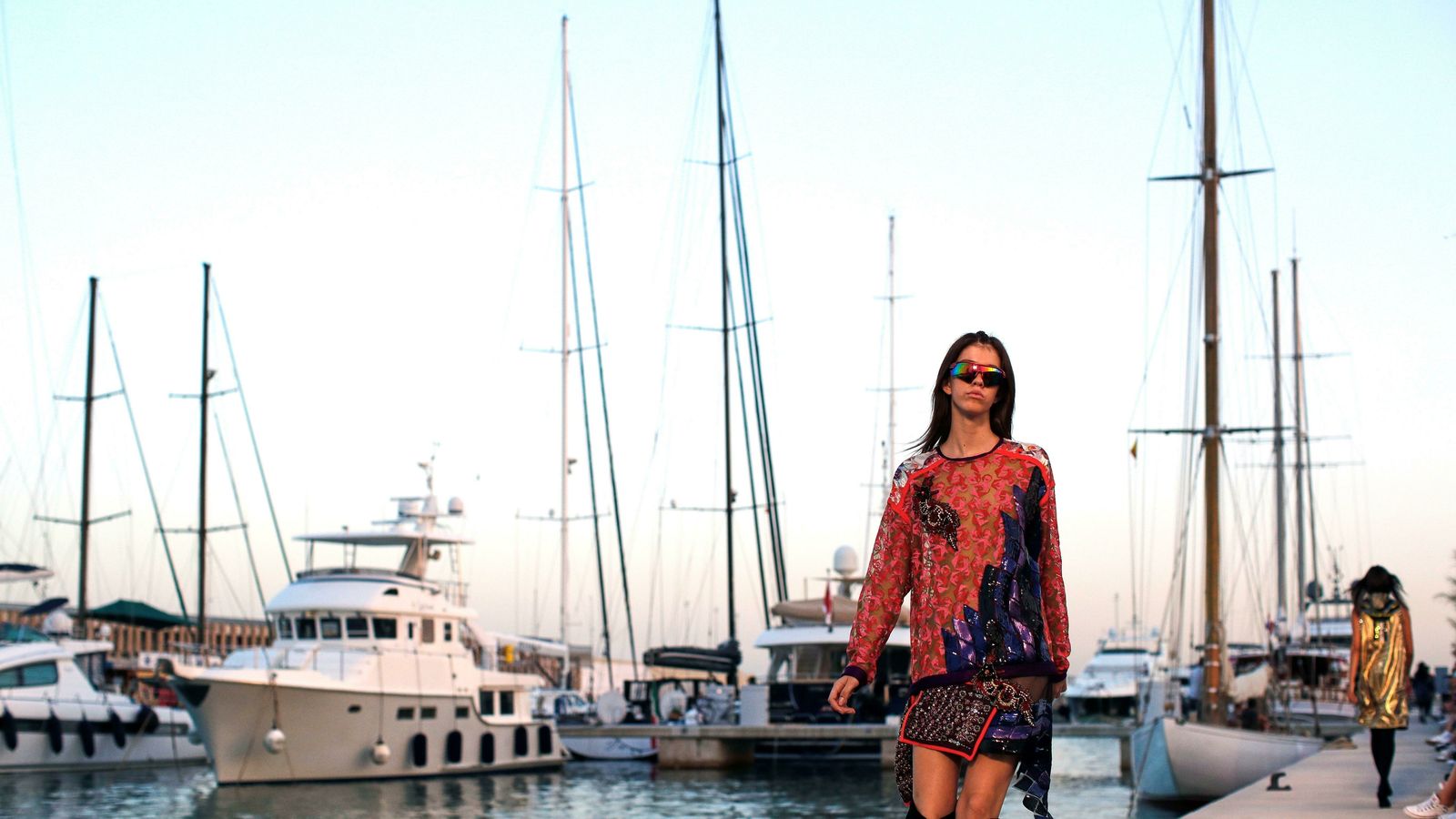 Una modelo con la característica camiseta de Custo desfila por el puerto de Marina Vela.