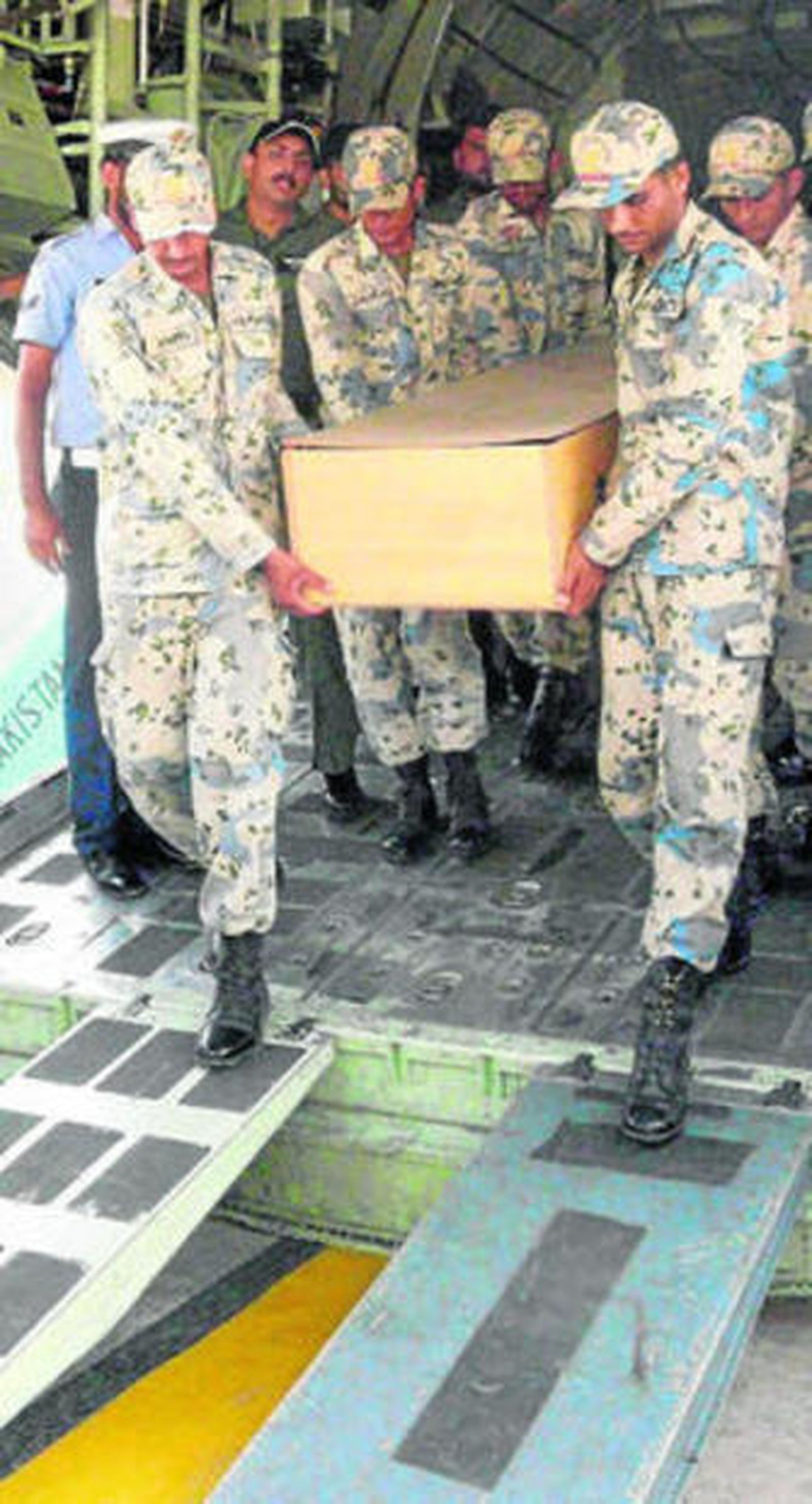 Miembros de las fuerzas aéreas paquistaníes trasladan uno de los cuerpos.
