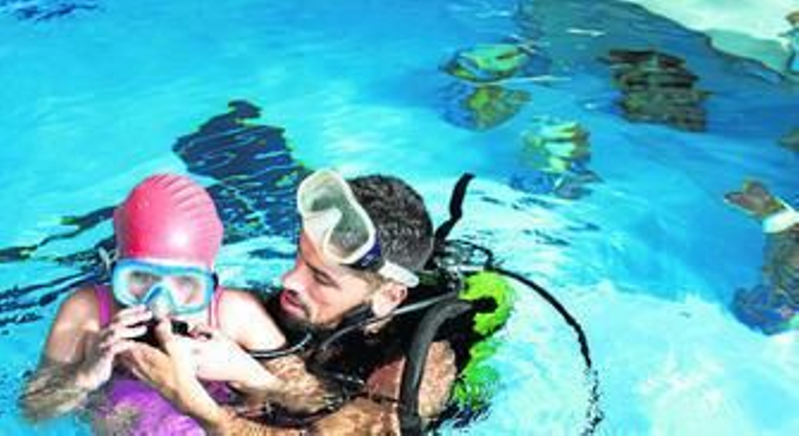 Escolares acompañados por bomberos de Huelva en la piscina del Andrés Estrada donde está el belén.