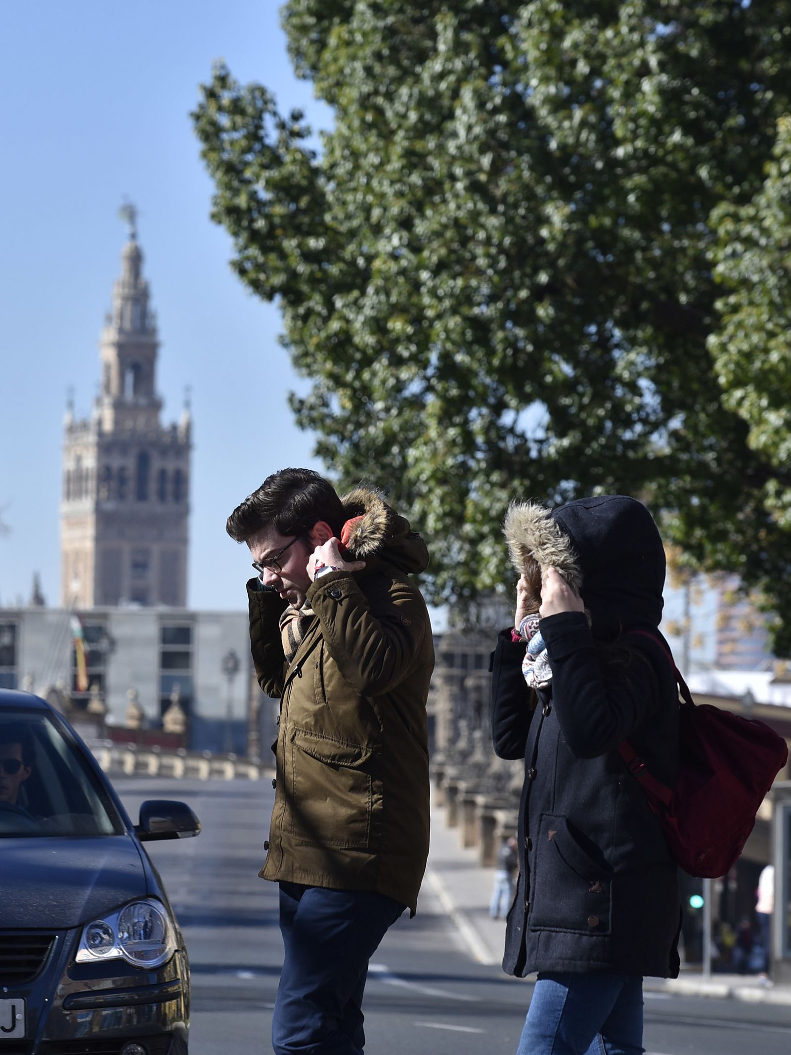 Dos personas se protegen del frío en Sevilla.