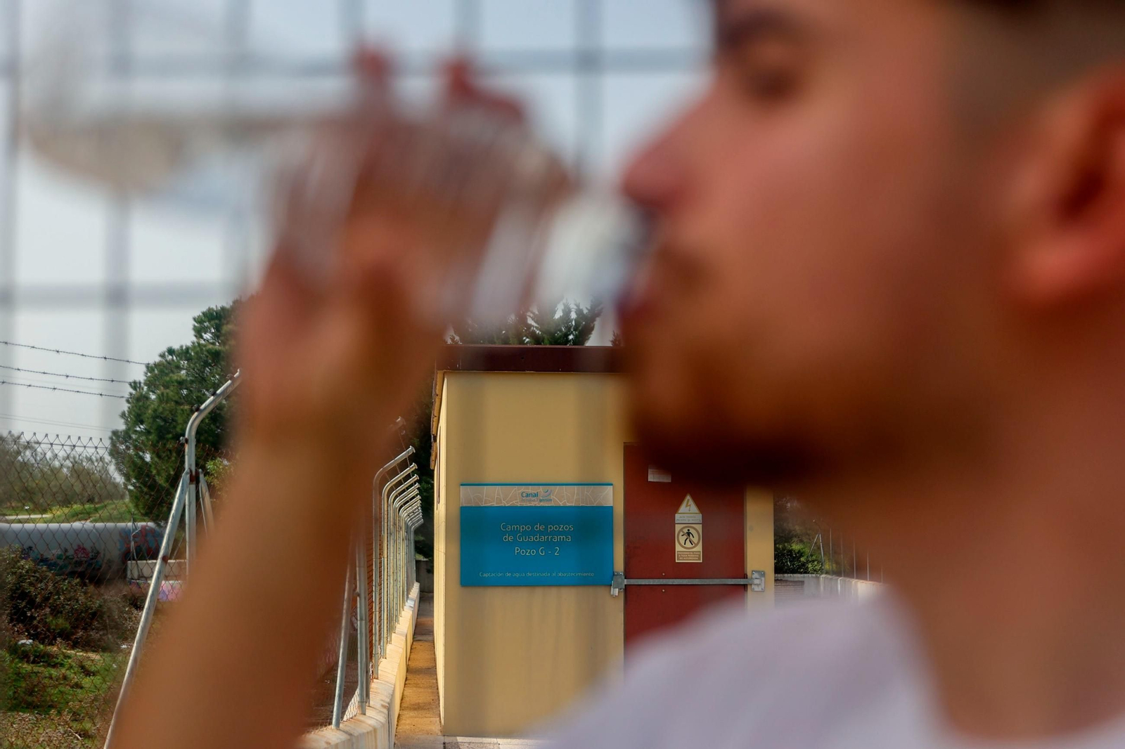 Un joven bebe una botella de agua Un joven bebe una botella de agua