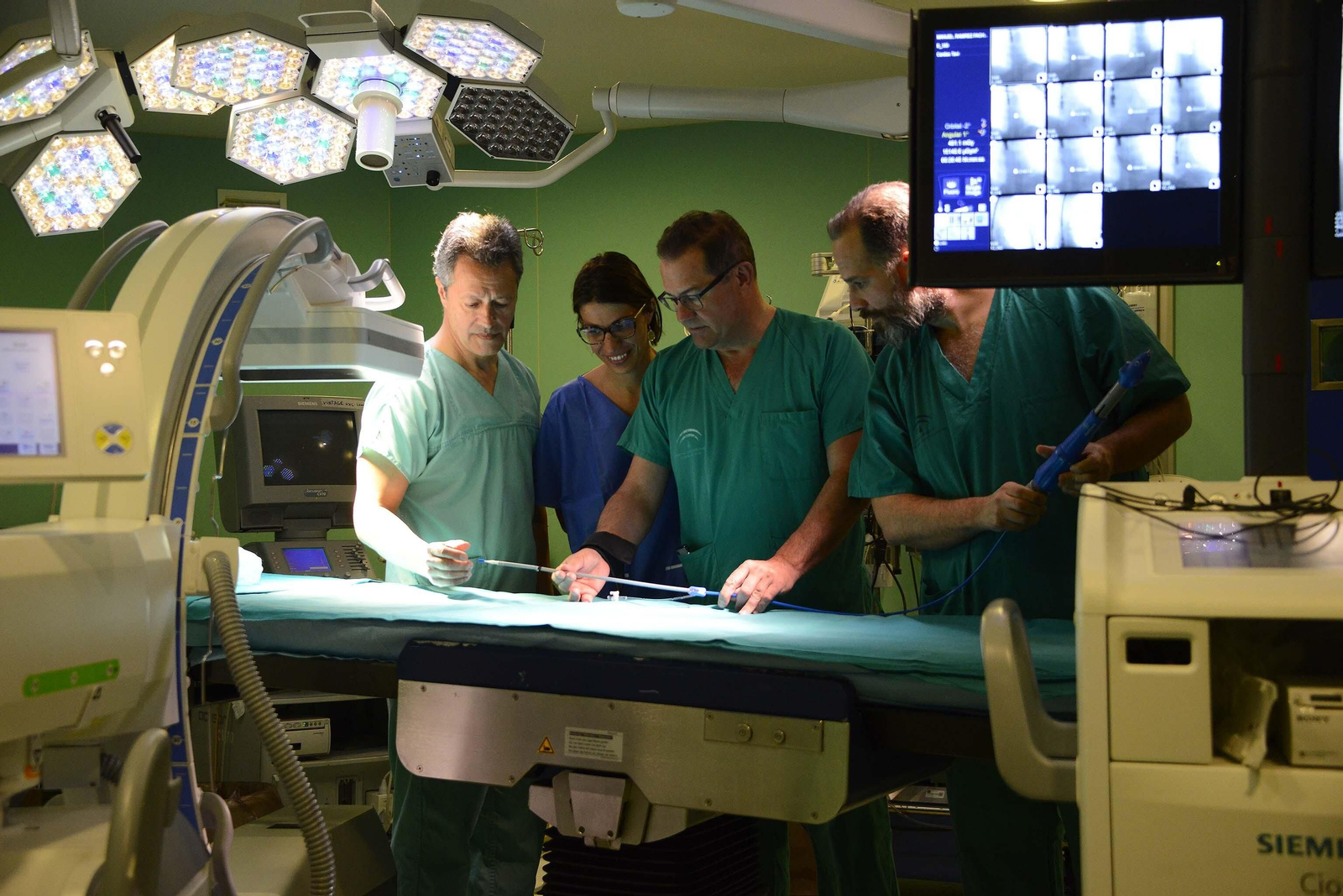 Tomás Daroca (izquierda) y Miguel Ángel Gómez (centro) con dos cirujanos que asistieron uno de los cursos sobre el procedimiento TAVI en un quirófano de Cirugía Cardíaca del Puerta del Mar.