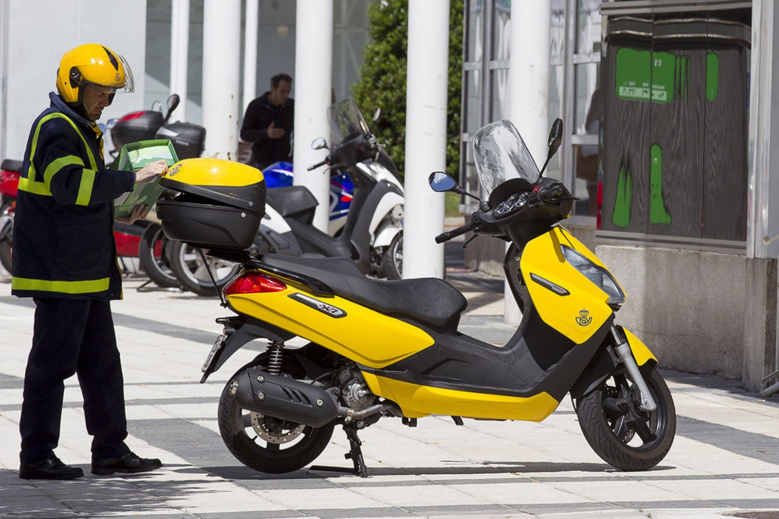 Cartero y moto de Correos en Huelva