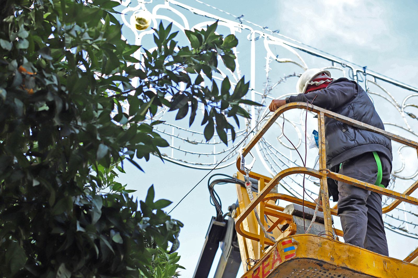 Un operario, terminando de instalar el alumbrado.