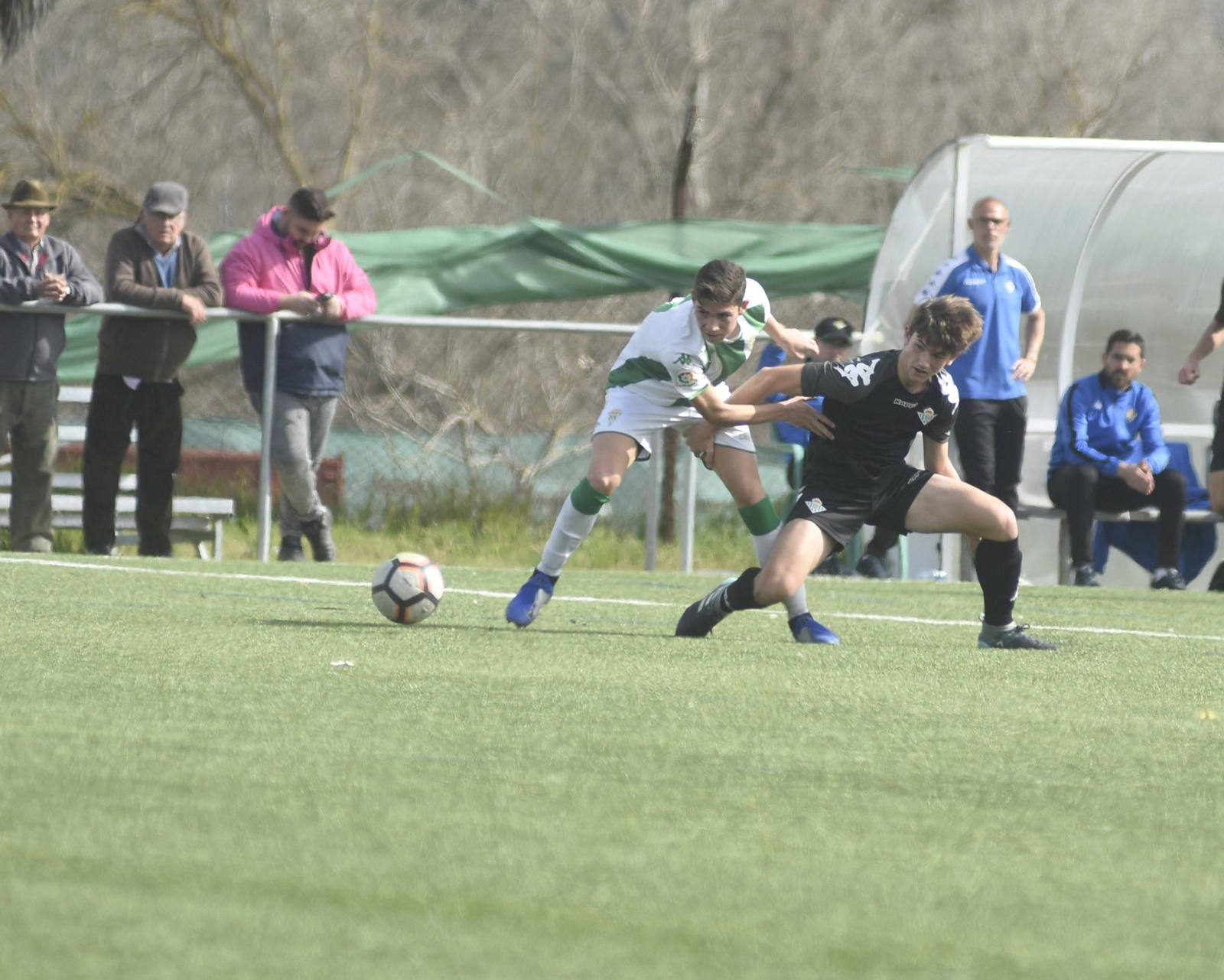 Un jugador del Córdoba se anticipa a uno del Betis.