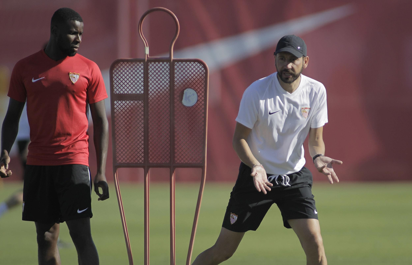 Machín da instrucciones con Amadou atento en la ciudad deportiva.