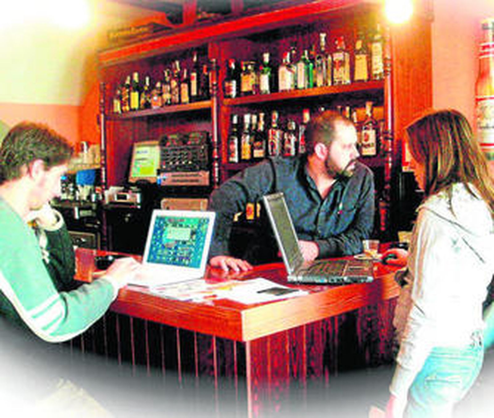 Varios vecinos utilizan sus portátiles en el Pub La Cueva.