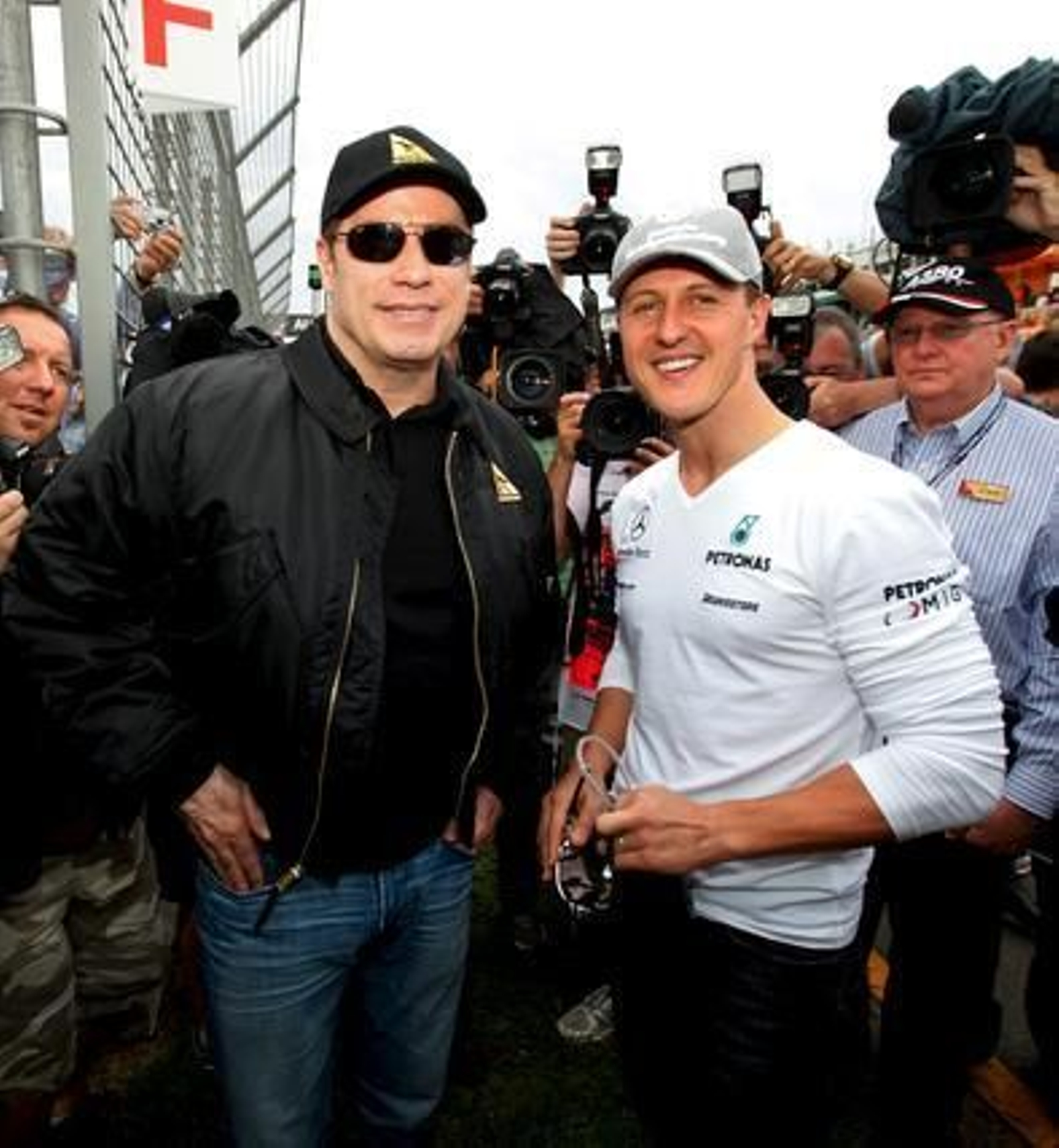 El actor John Travolta posa con Schumacher antes del inicio de la carrera.