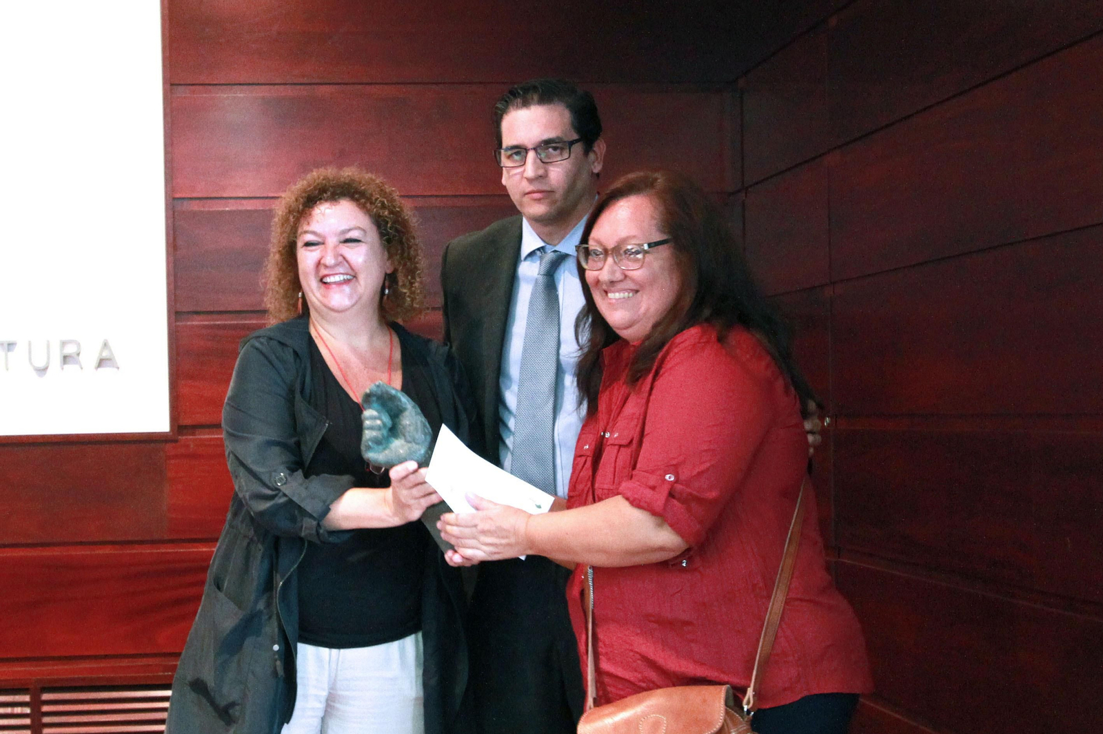 Ana Isabel Espinosa, a la derecha, recoge el galardón junto a Rafael Muñoz y Eva Tubío.