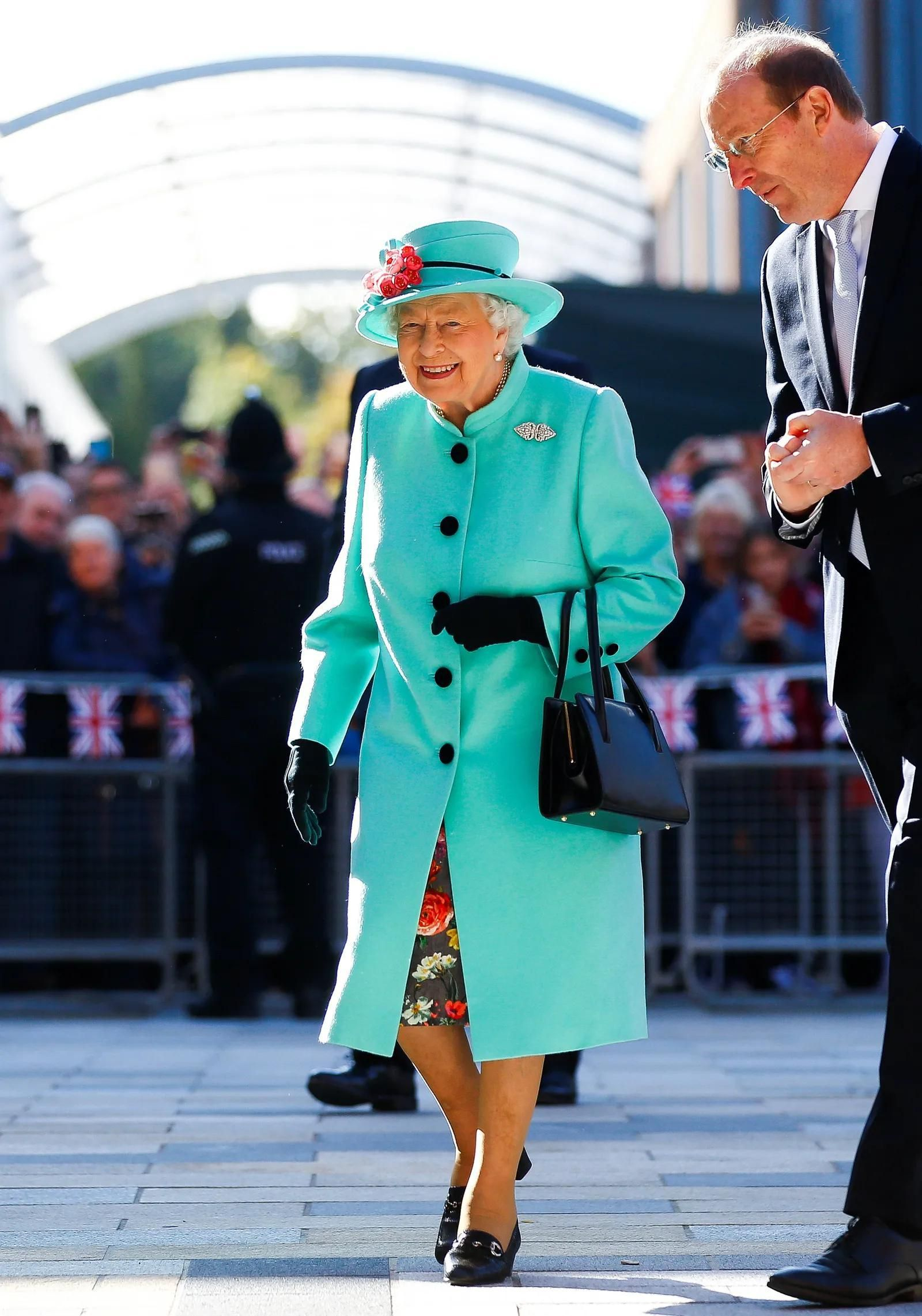 La Reina Isabel II de Inglaterra con un look en turquesa.