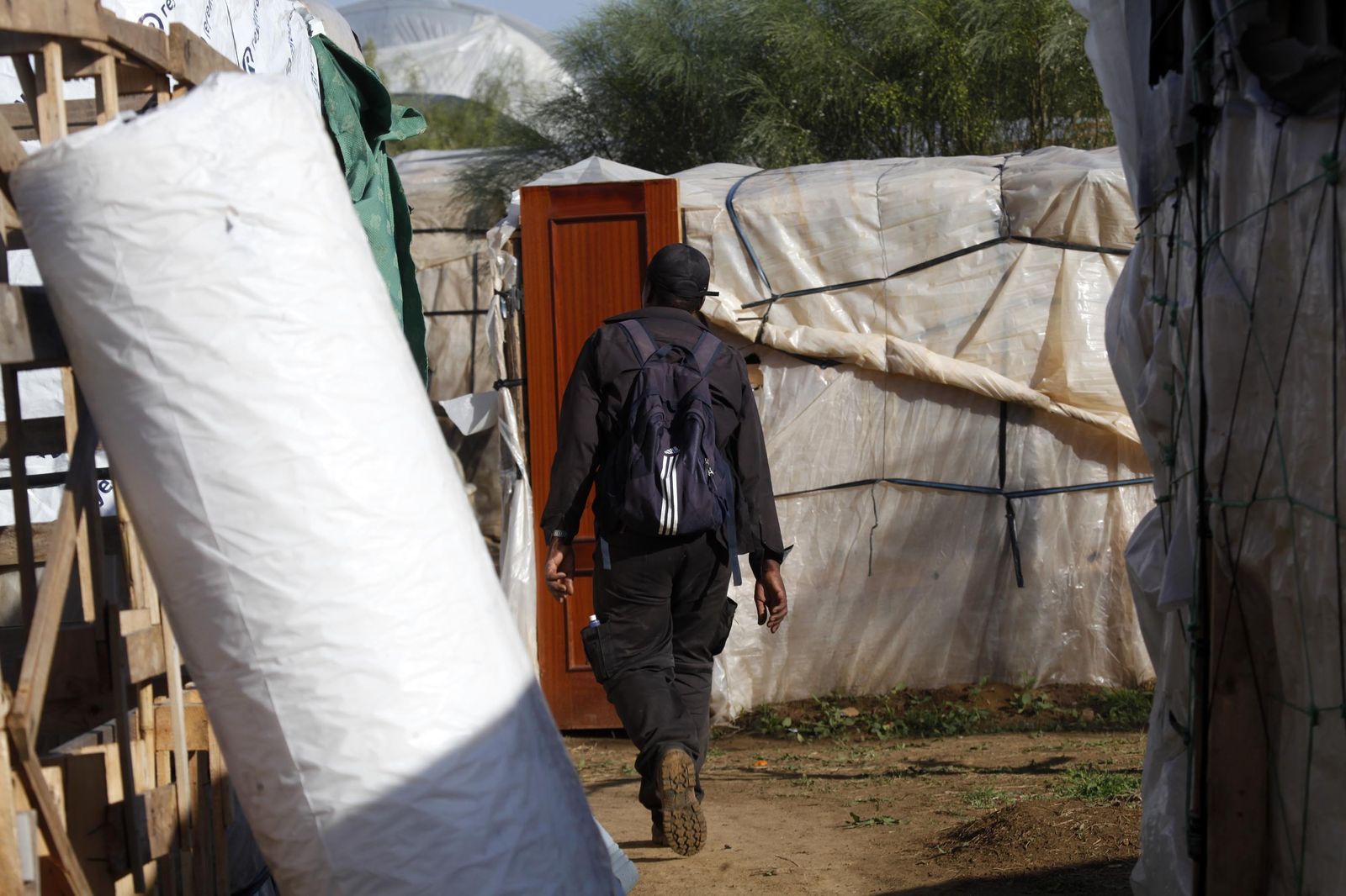 Un temporero camina por un asentamiento.