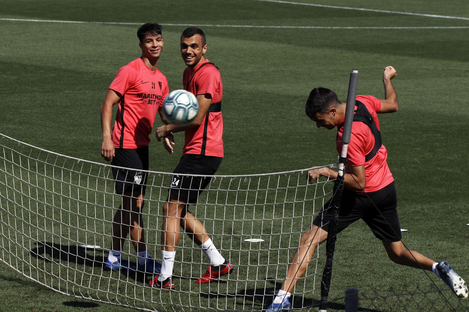 Joan Jordán sonríe con Óliver Torres mientras Genaro cabecea ante una red de 'futvoley'.