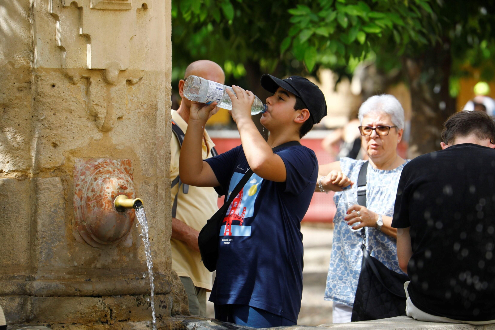 Turistas se refrescan en el Patio de los Naranjos de la Mezquita-Catedral de Córdoba. Turistas se refrescan en el Patio de los Naranjos de la Mezquita-Catedral de Córdoba.