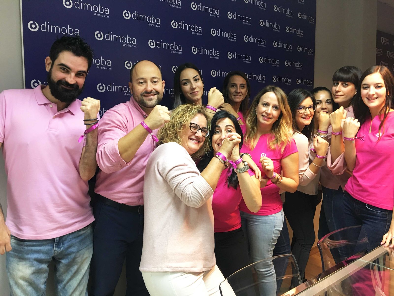 Empleados de Dimoba, con el color rosa, apoyando la campaña.