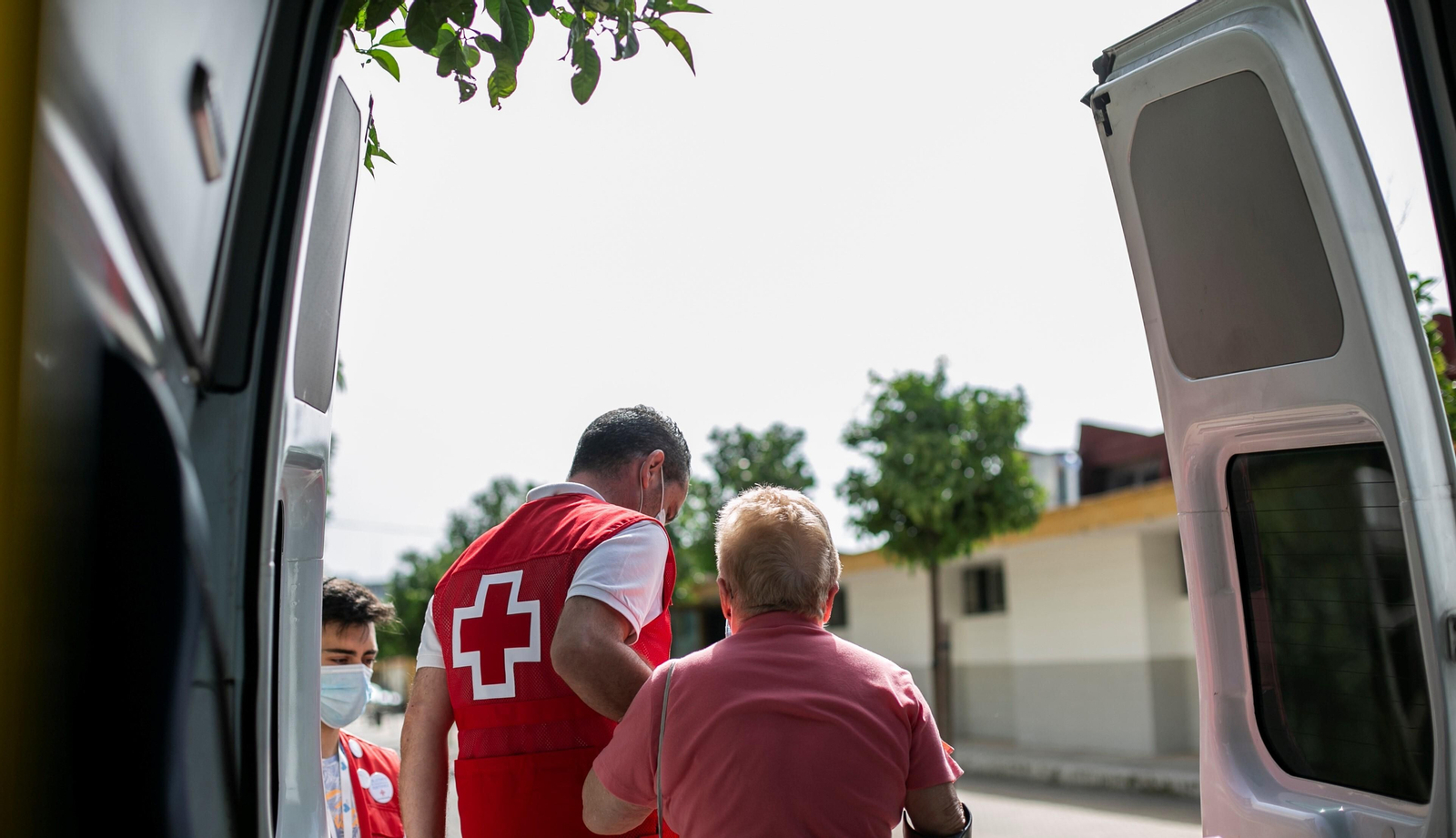 Un miembro de Cruz Roja ayuda a una mujer a salir de una ambulancia.