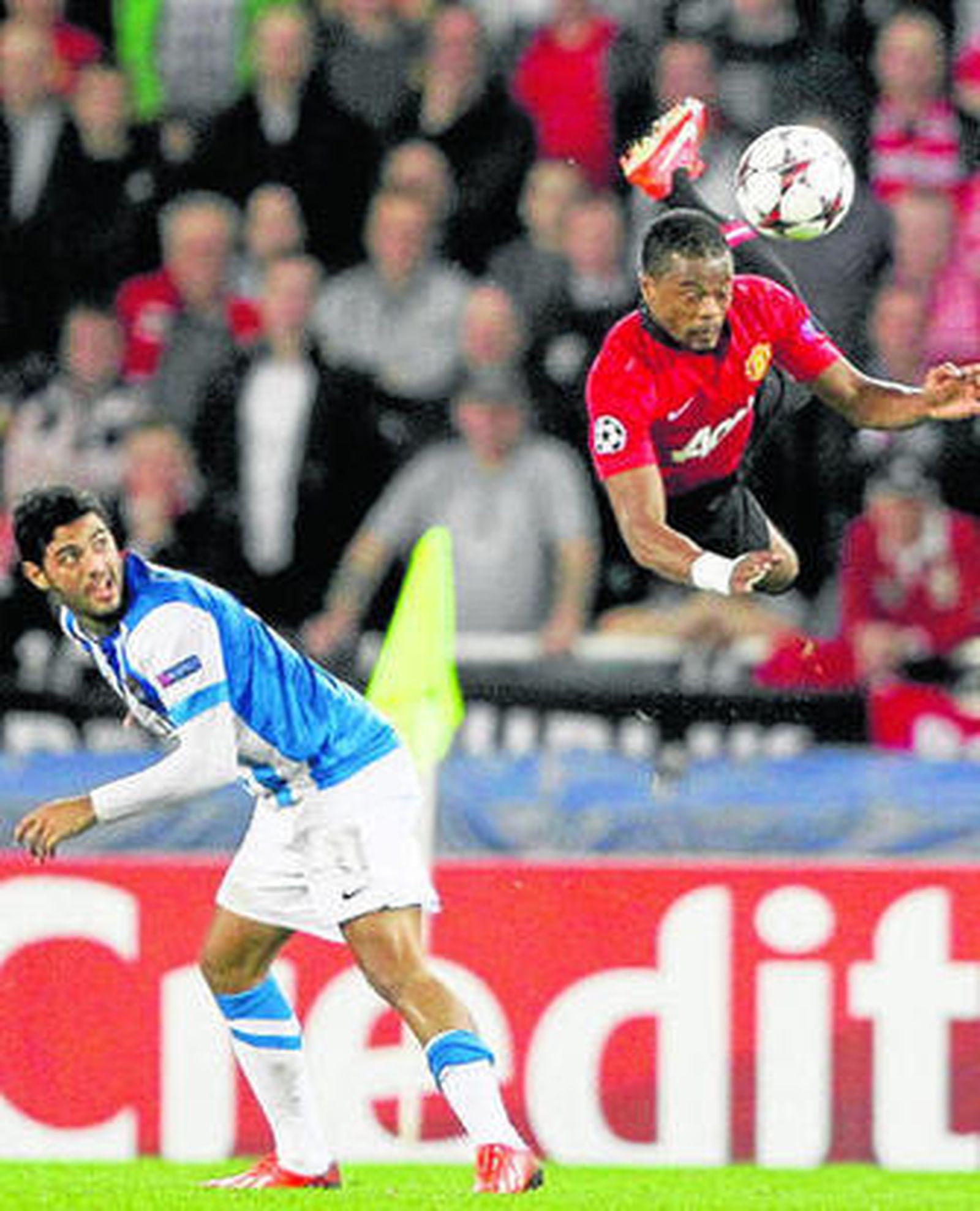 Evra, del ManU, vuela ante la mirada del realista Carlos Vela.
