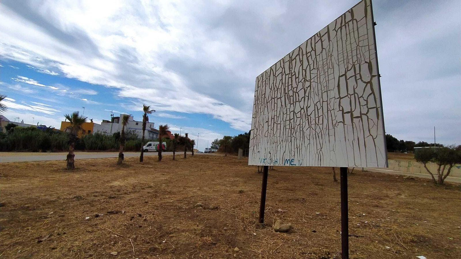Cartel que anunciaba las obras del Plan E para el punto limpio de Camposoto, ya descolorido y destrozado por el paso del tiempo.
