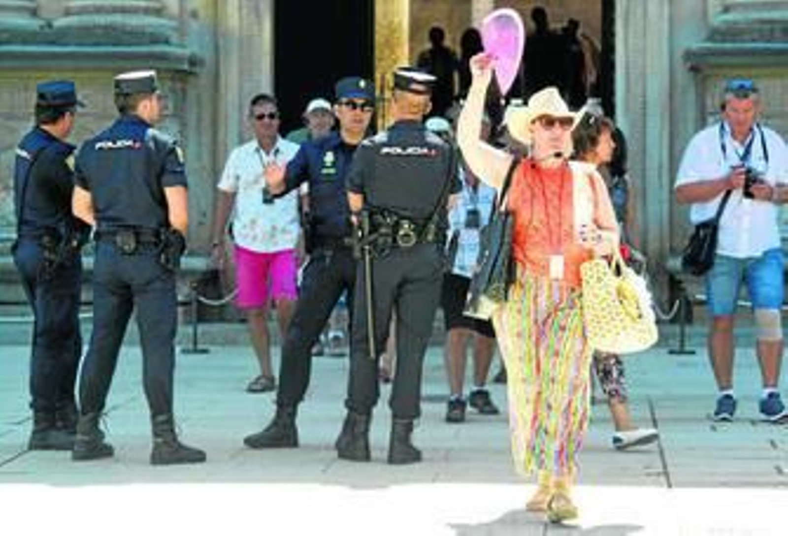 Agentes de la Policía Nacional junto a un grupo de turistas.
