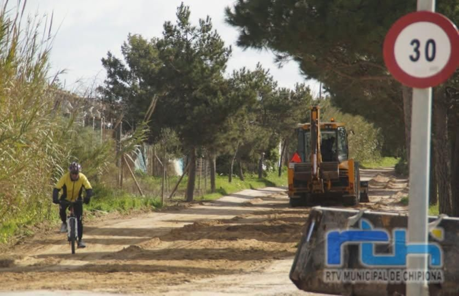 Una grúa realiza trabajos de mantenimiento en una vía pecuaria de Chipiona.