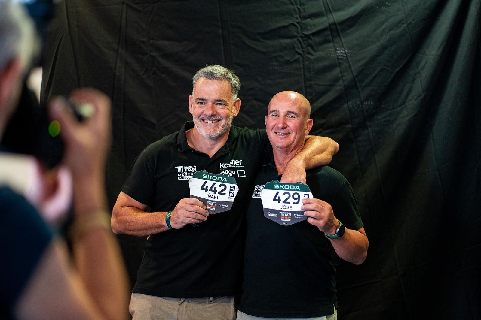 Dos de los participantes de la quinta edición de la Titan Desert Almería posan con sus respectivos dorsales.