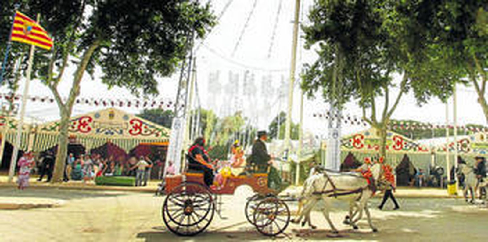 Un coche de caballos pasea por la avenida principal de la Feria de Primavera.