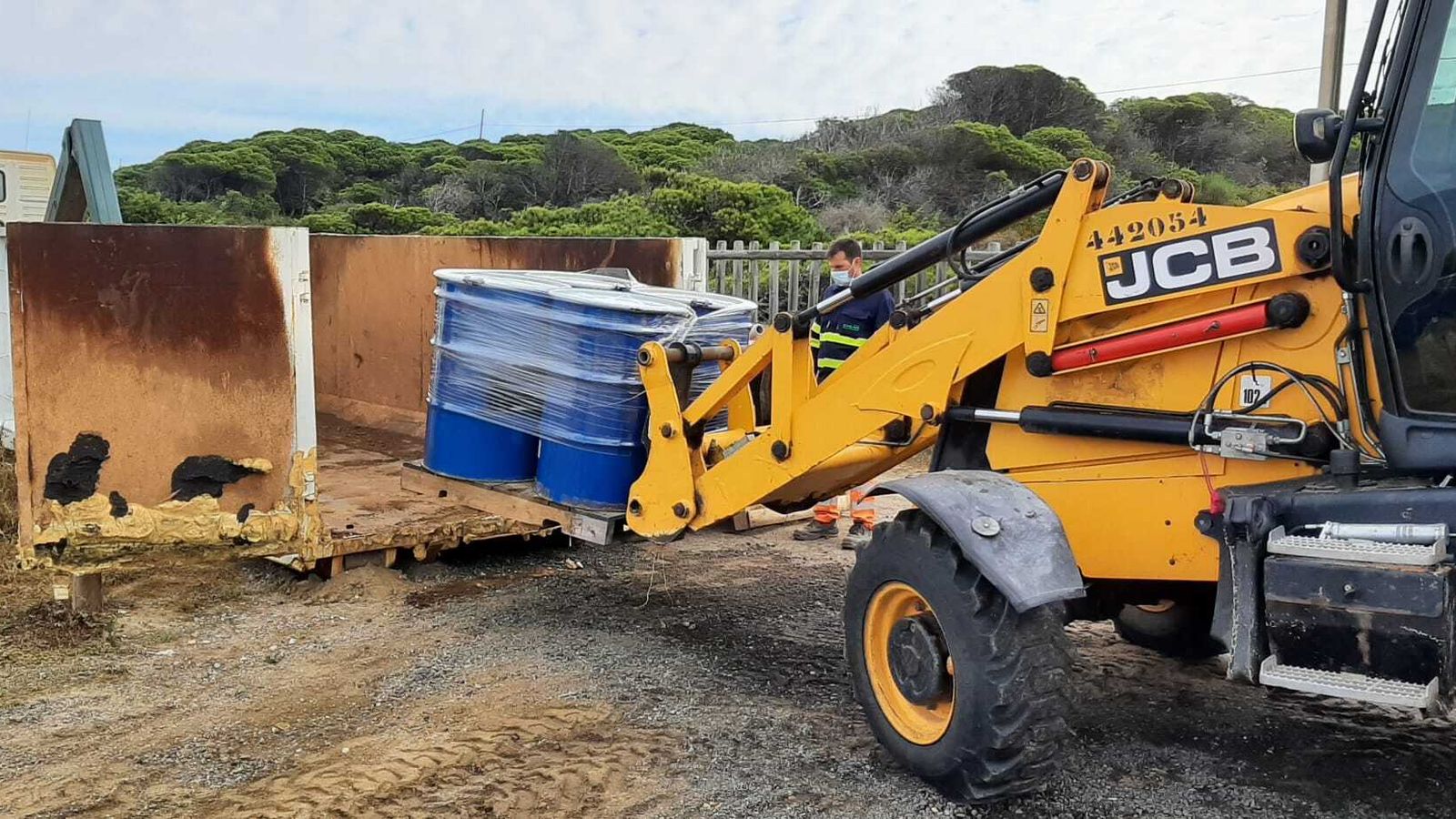 Carga de los bidones en un contenedor para su retirada de la playa.