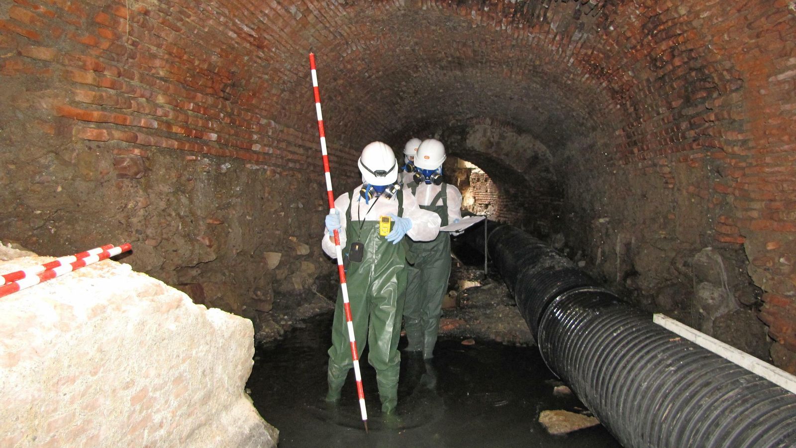 Varios trabajadores inspeccionan el interior del colector tras una obra de reparación.