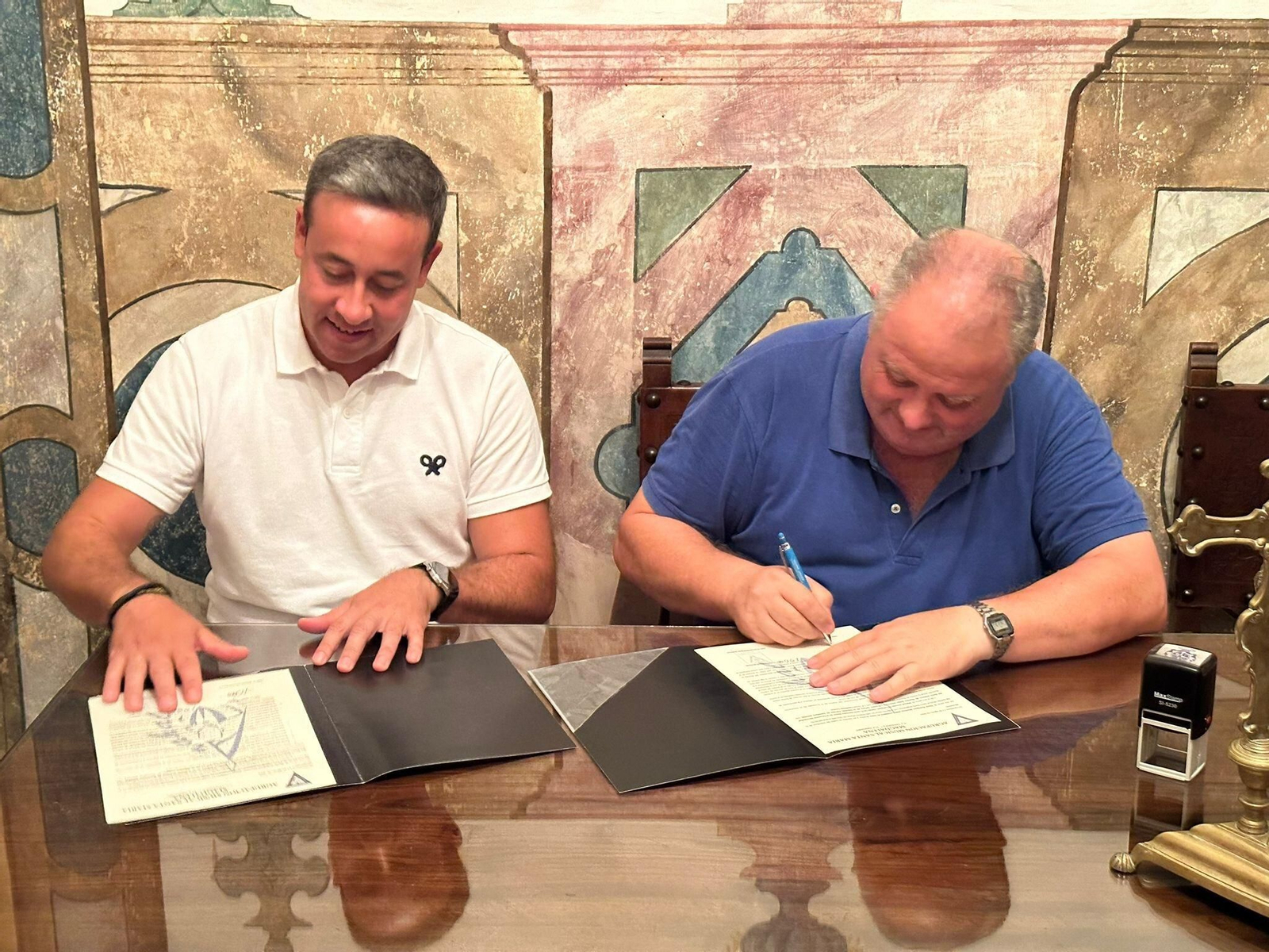 David Rodríguez, director de la banda, firma el contrato con la corporación cantillanera