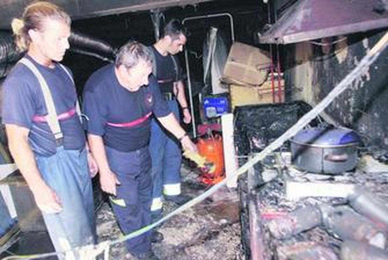 Los bomberos revisan el lugar donde tuvo lugar el fuego.