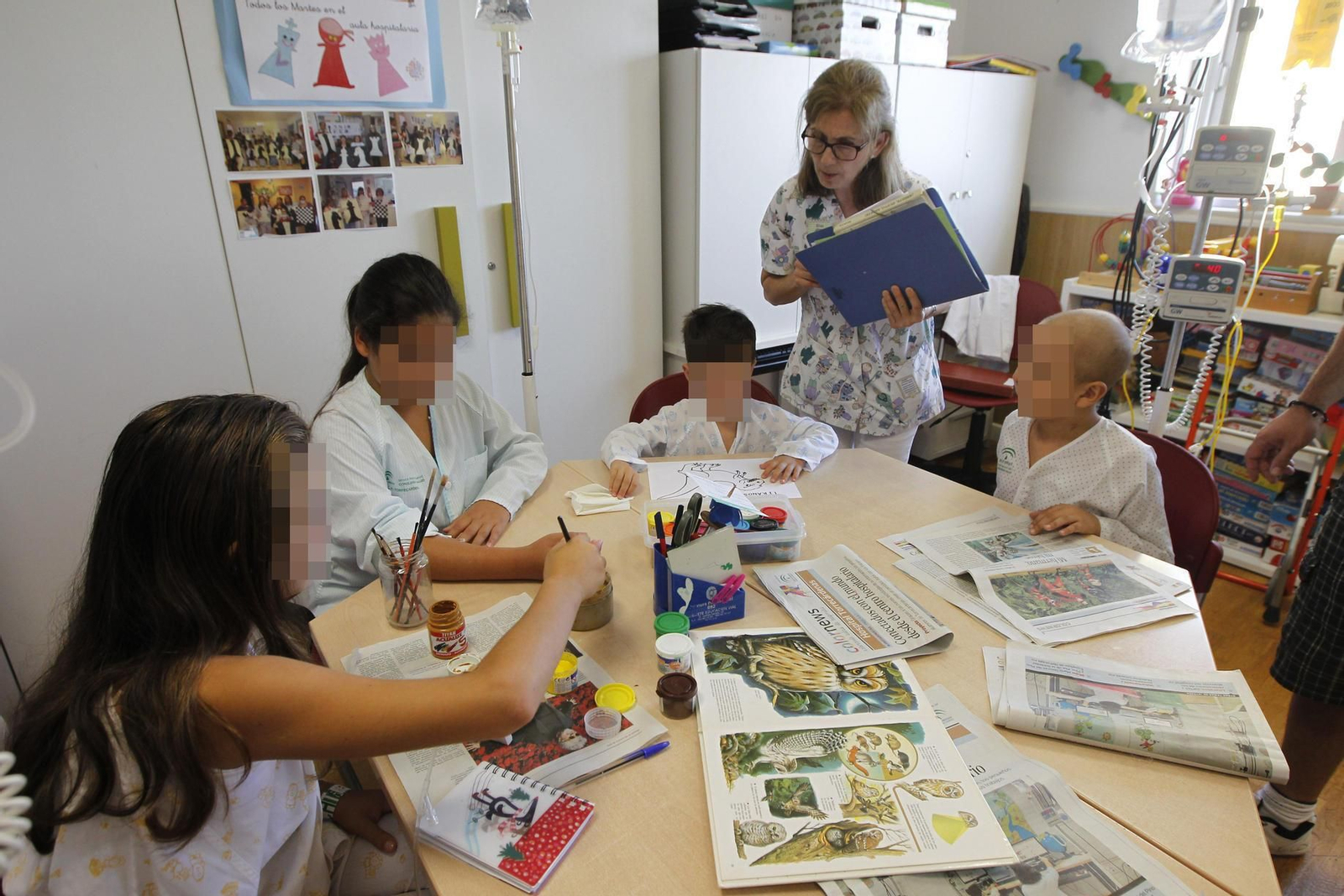 Los menores ingresados realizan actividades en una de las aulas hospitalarias con la profesora Elisa Bernárdez, con más de treinta años de trayectoria en el centro.