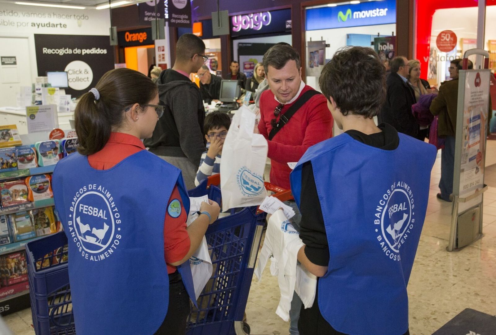 Dos voluntarios en una superficie comercial de Huelva.