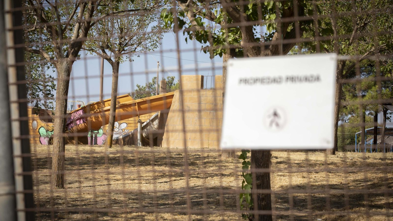 Zona de atracciones infantiles vista desde el exterior, en el que se ven toboganes con grafitis