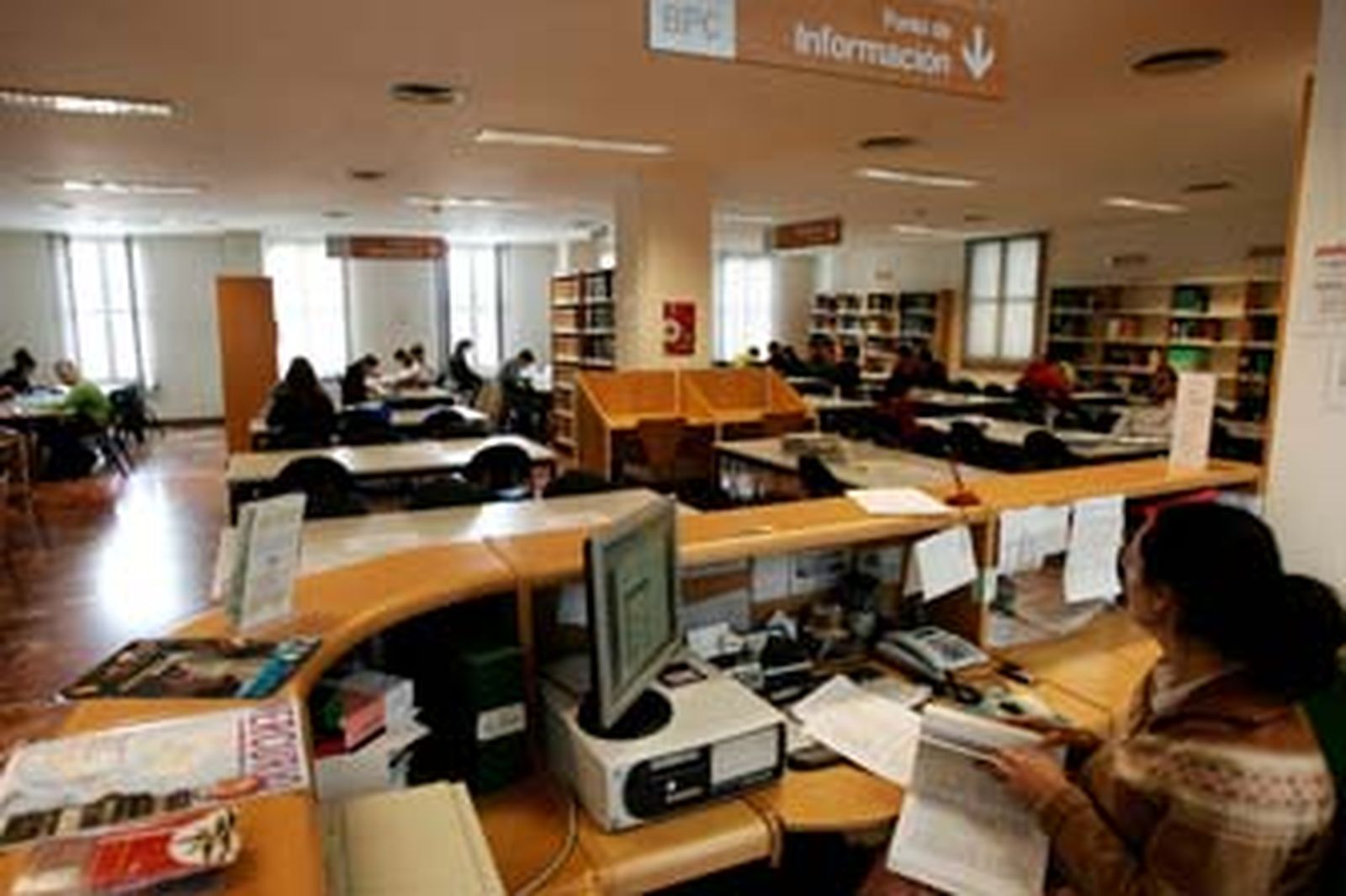 Varios pasajeros pasan el tiempo mientras esperan la salida de los trenes. /Jesús Marín