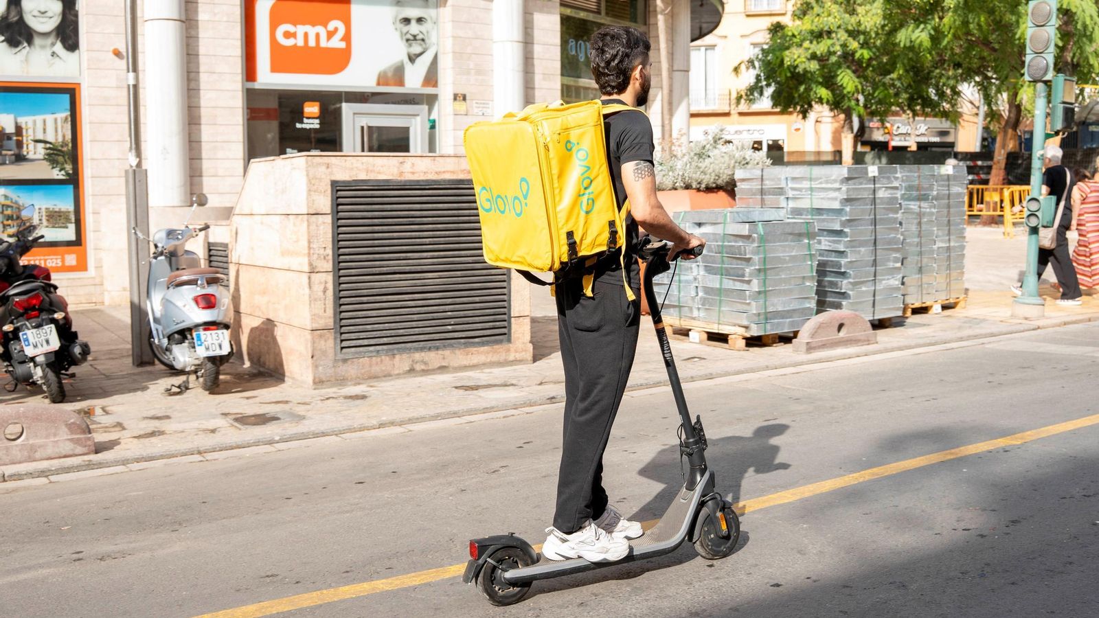 Un trabajador usa el patinete elétrico como vehículo de transporte, sin casco