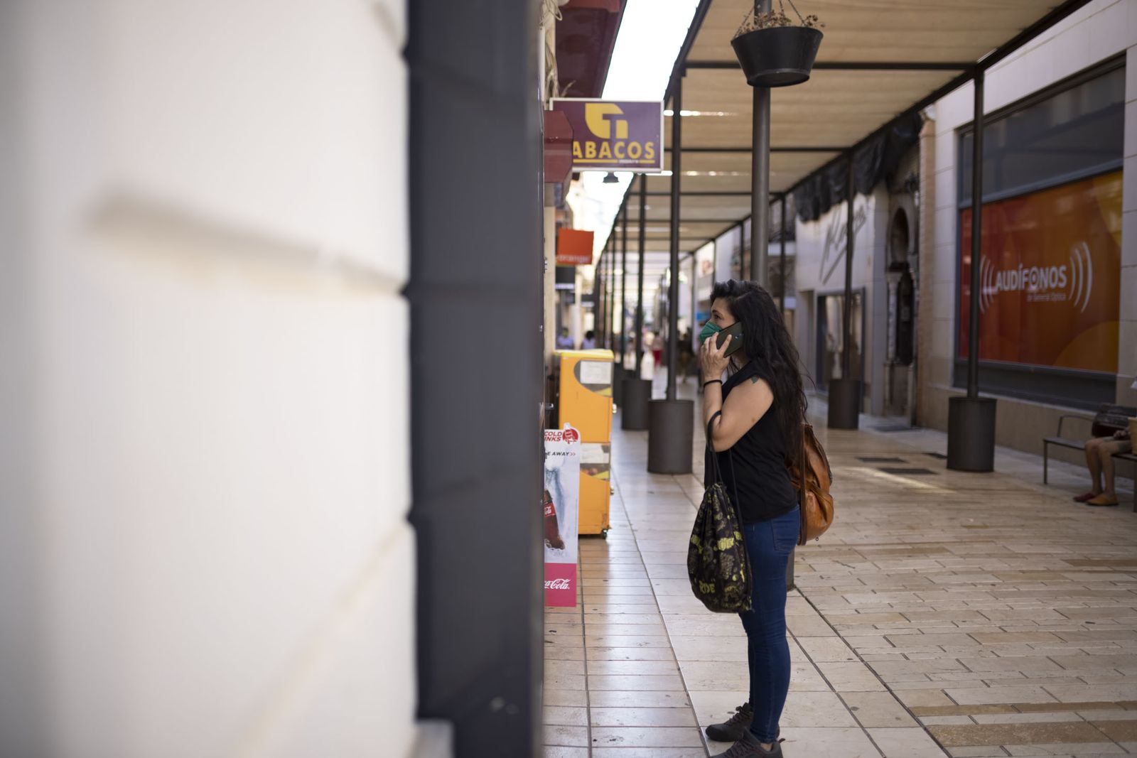 Una mujer con mascarilla mira un escaparate en la capital.