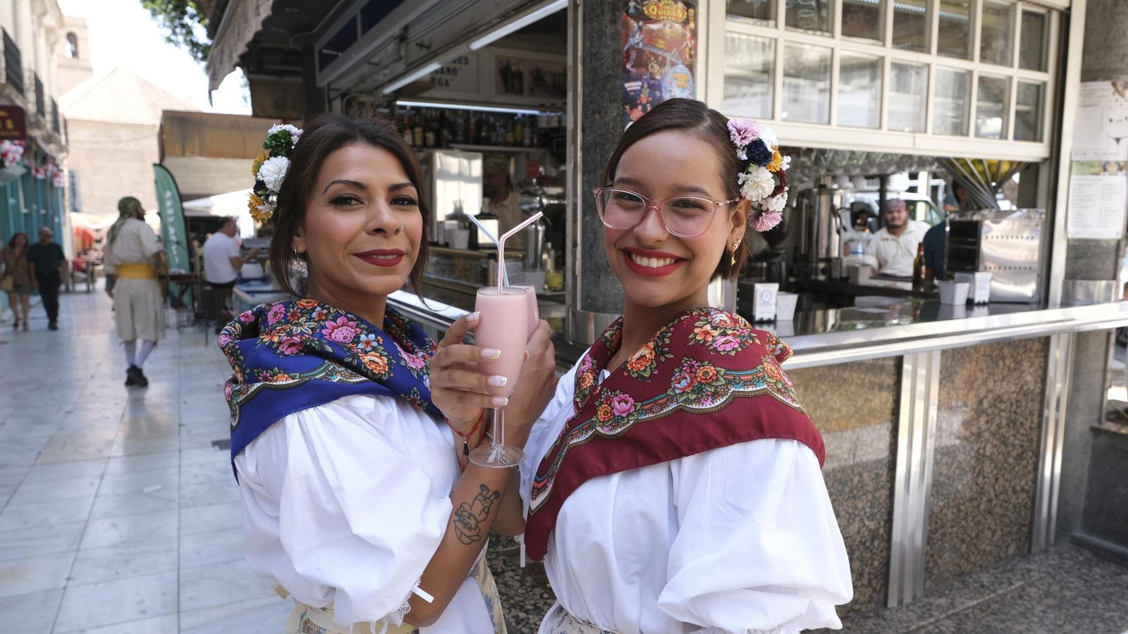Camareras vestidas con los trajes típicos posando con un 'americano'.