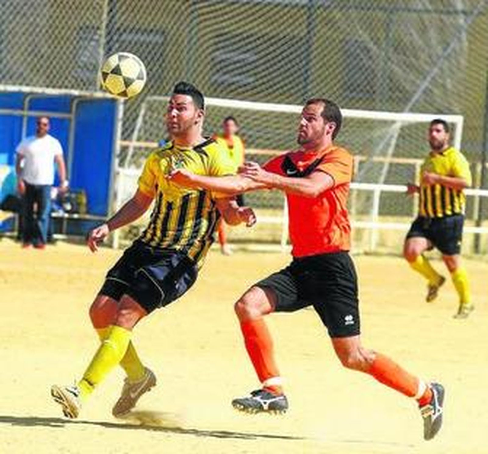 Dos jugadores pugnan por un balón dividido.