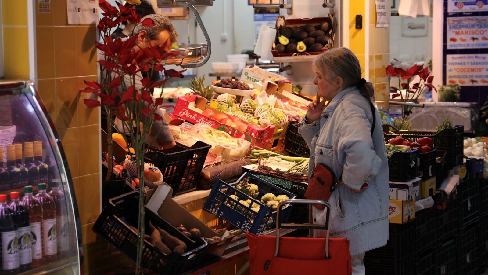Una mujer compra en una frutería de barrio en Sevilla.