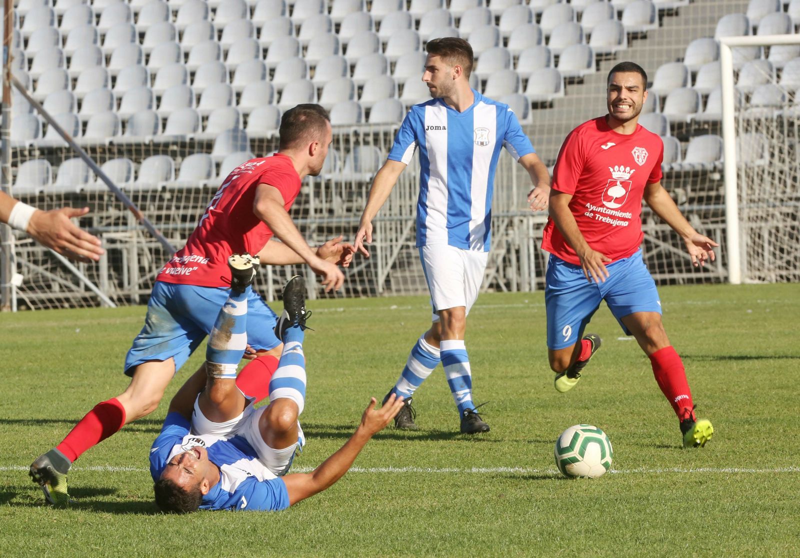 Juan Rosillo se duele en el suelo de una falta de un futbolista del Trebujena.