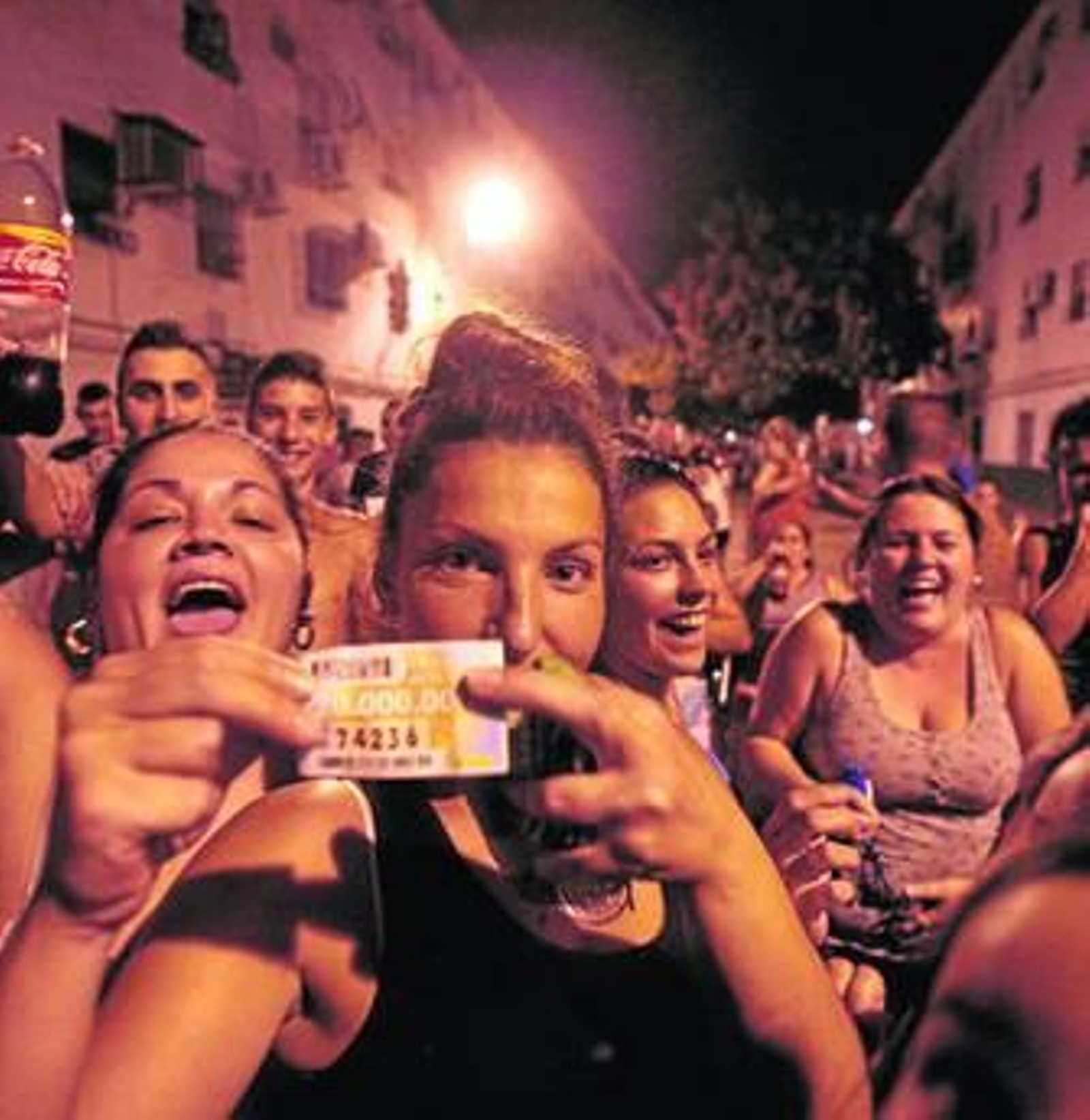 Una joven muestra su cupón rodeada de amistades, entre ellas, la esposa del cuponero (derecha).