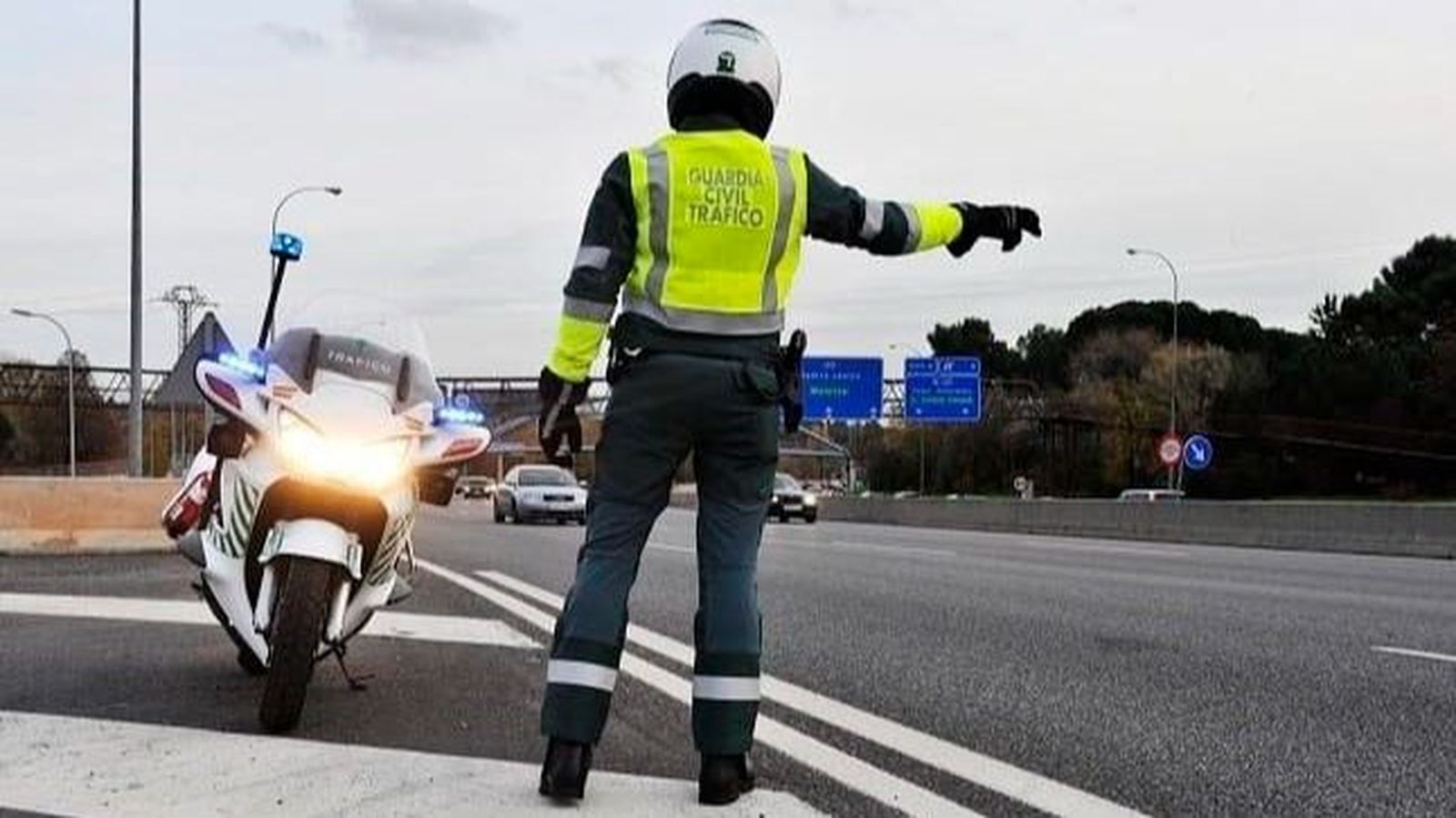 Un agente de la Guardia Civil de Tráfico junto a su motocicleta