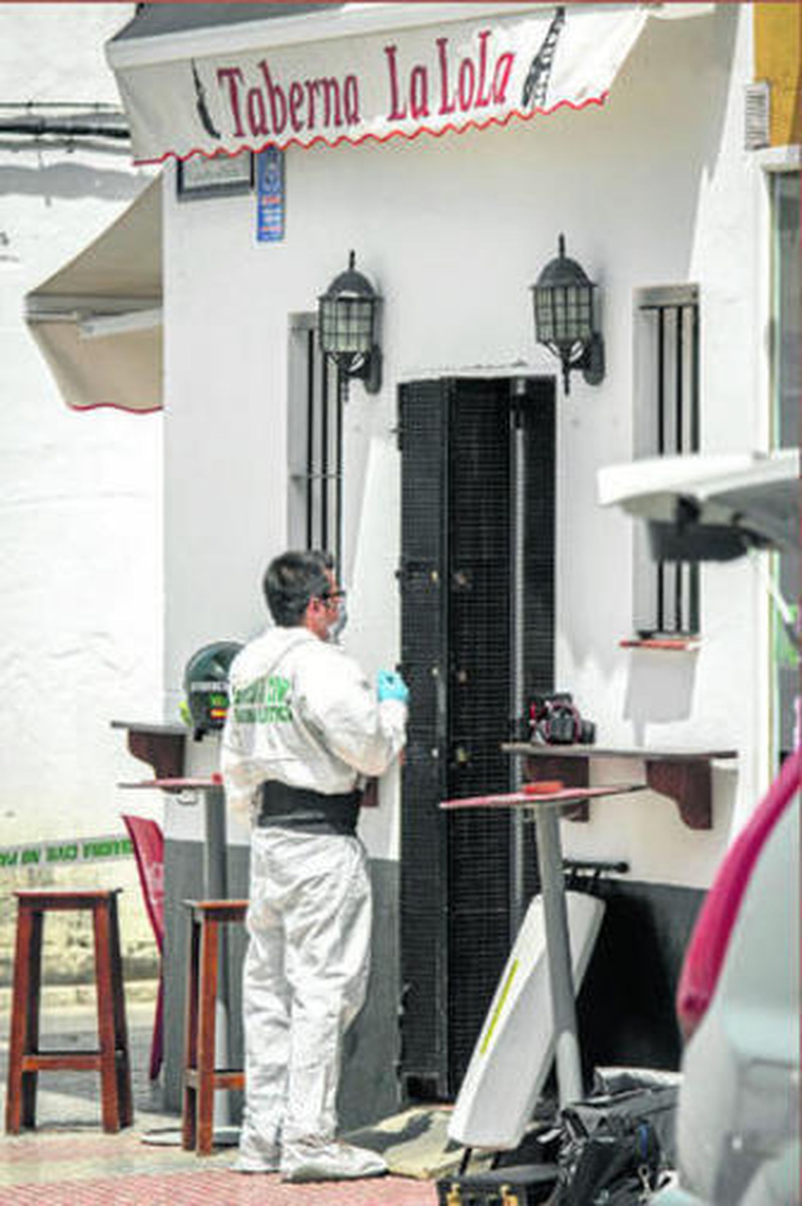 Un agente de la Policía Científica de la Guardia Civil, en la puerta de La Lola.
