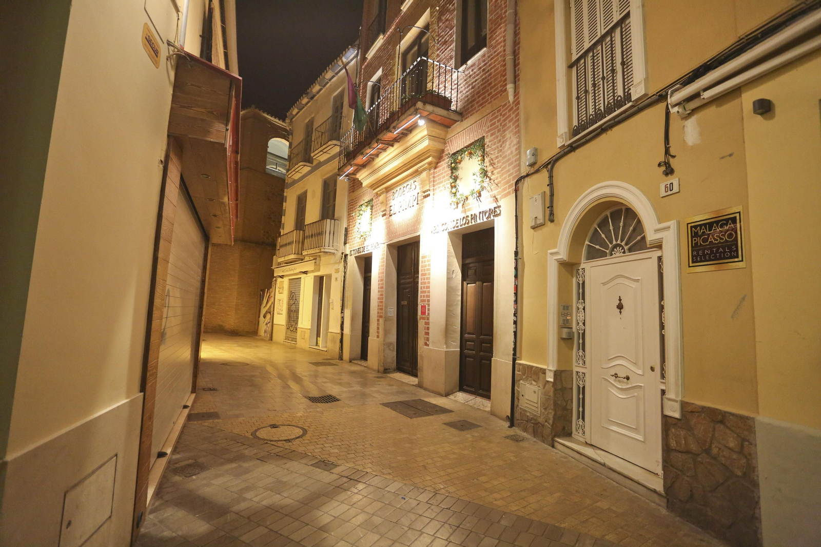 El coronavirus dibuja una noche desierta en el centro de Málaga, en fotos