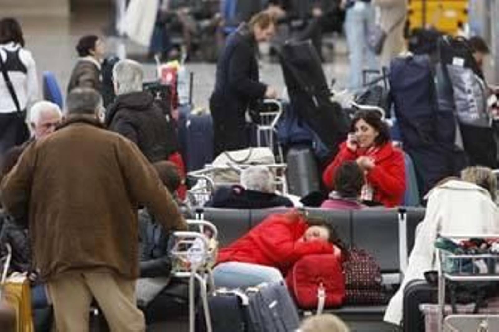 Una escena que ayer fue habitual en la sala de espera del aeropuerto de Jerez: pasajeros intentan descansar utilizando sus bultos y maletas como almohadas. /Juan Carlos Toro