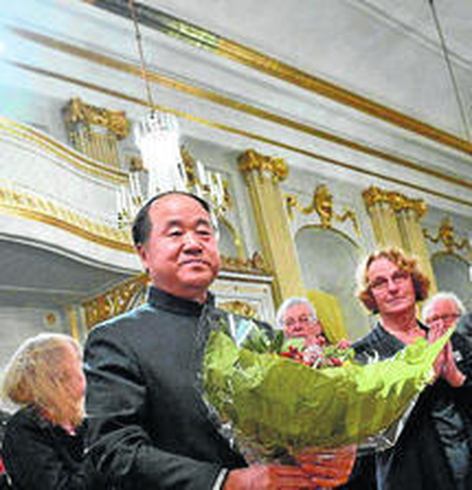 Mo Yan recibe un ramo de flores tras la lectura de una de sus obras en la Academia sueca. / EPA